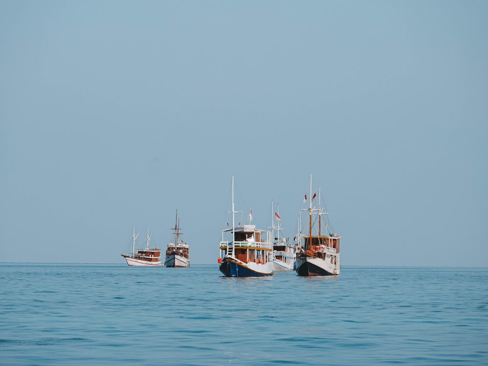 un gruppo di barche che galleggiano sopra un grande specchio d'acqua