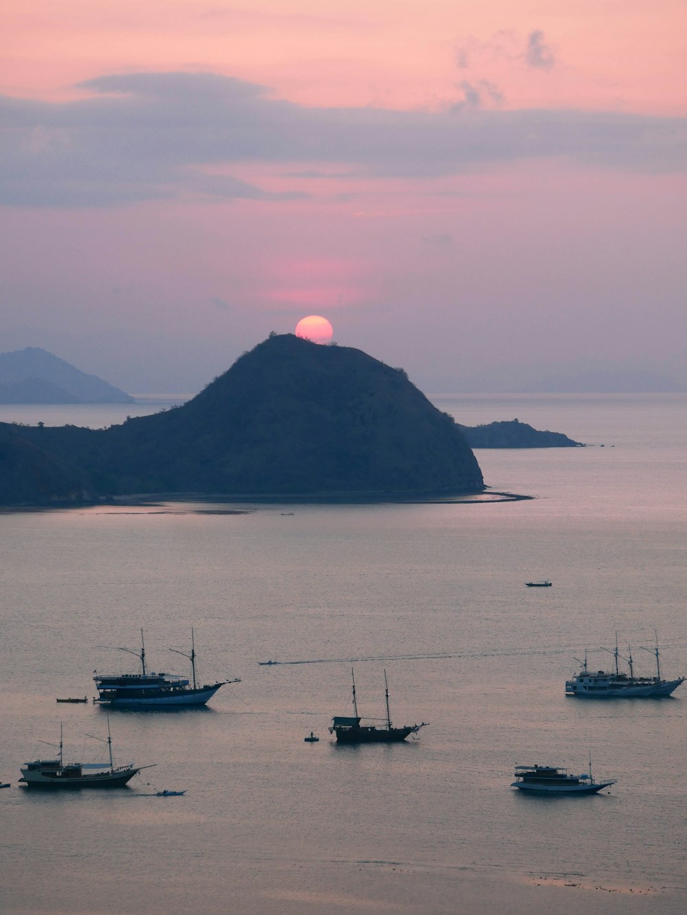 a group of boats floating on top of a large body of water