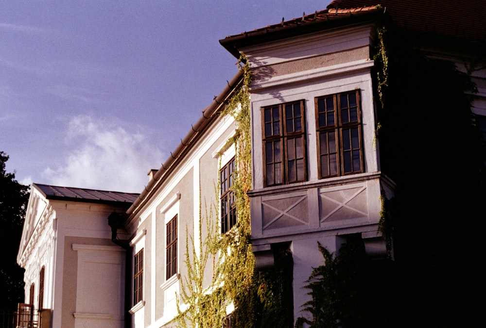 a tall white building with ivy growing on it's side