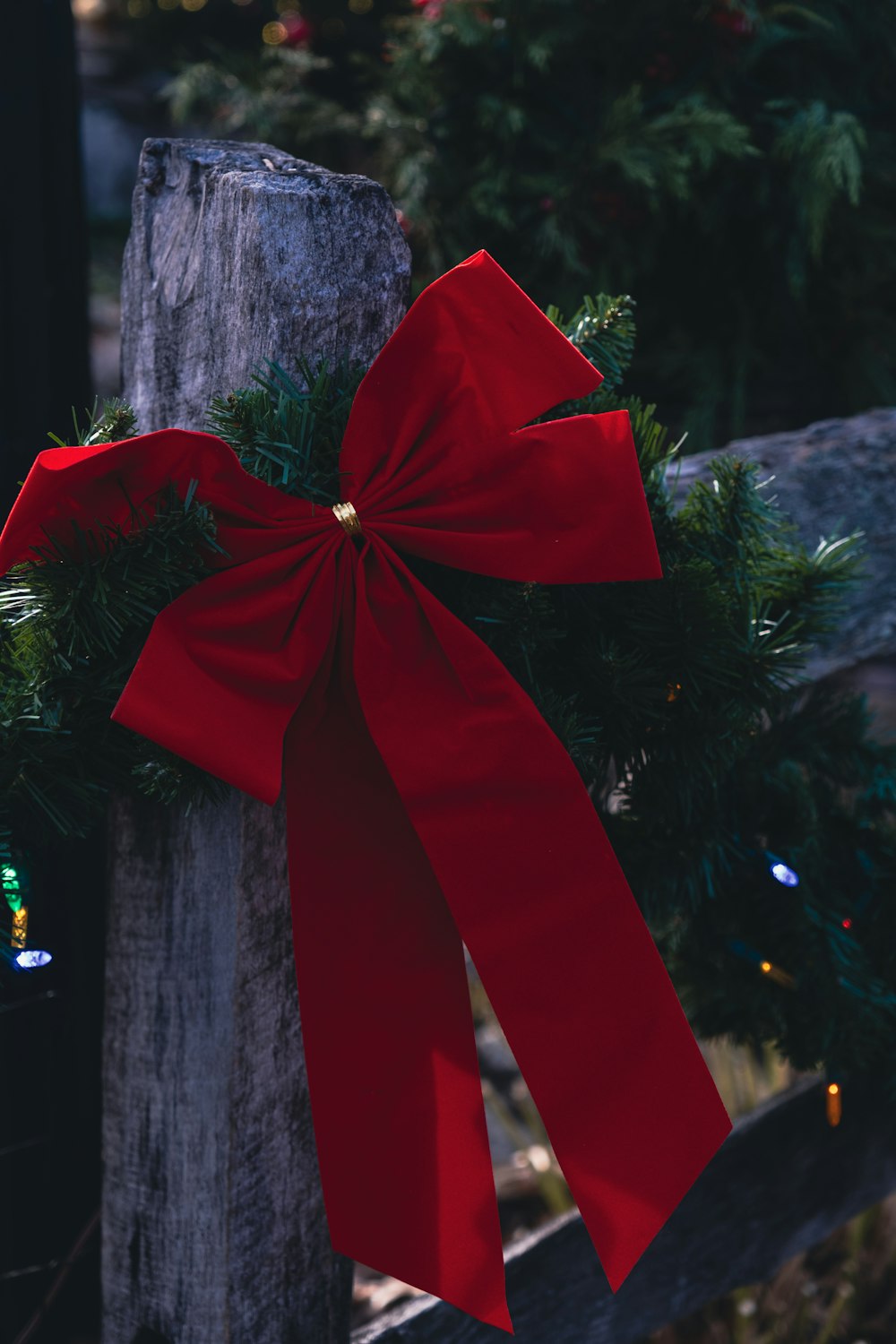 a red bow tied to a wooden post