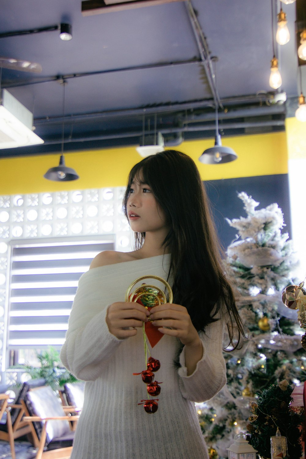 a woman standing in front of a christmas tree