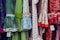 A colorful display of dresses with various polka dot and floral patterns. The fabrics feature a mix of vibrant colors including green, blue, red, and white. Ruffled sleeves and lace accents add texture, while price tags are visible hanging from some of the garments.