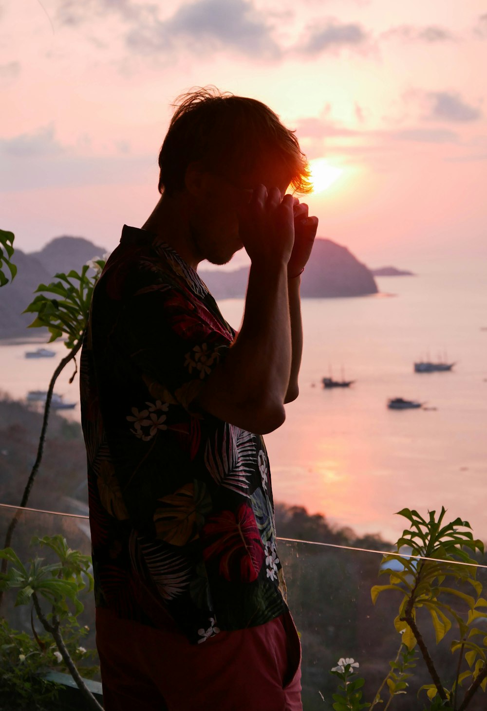 a man standing on top of a hill next to the ocean