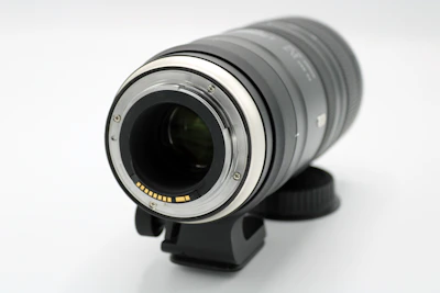 Close-up of a high-end camera lens catching light, set against a neutral backdrop.