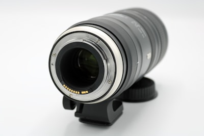 Close-up of a camera lens on a tripod in a studio setting.