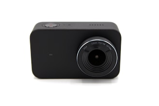 A compact, black rectangular camera with a prominent lens. The lens has markings for F2.8, 3.2mm, FOV 145, and UV filter. A small red button can be seen on the top, indicating a recording function.