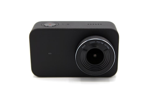 A compact, black rectangular camera with a prominent lens. The lens has markings for F2.8, 3.2mm, FOV 145, and UV filter. A small red button can be seen on the top, indicating a recording function.
