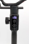 Modern video gimbal resting on a clean white surface with subtle gold highlights.