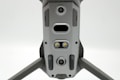 A close-up view of a drone's underside, showcasing various sensors, cameras, and LEDs arranged symmetrically along its body. The gray, metallic finish gives a sleek, modern appearance.