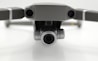 Close-up view of a drone's front, featuring two cameras on either side with a prominent central lens, positioned against a neutral background.