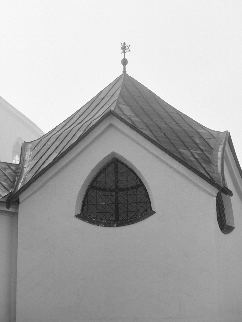 a black and white photo of a church with a cross on top