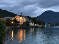 Evening view of the lakefront with soft lighting highlighting the property’s architecture.