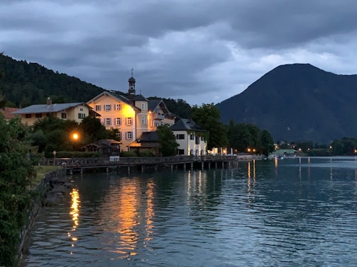 A serene lakeside view with a small sauna building at sunset.