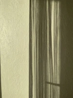 A serene white wall with subtle shadows creating gentle patterns in the afternoon light.