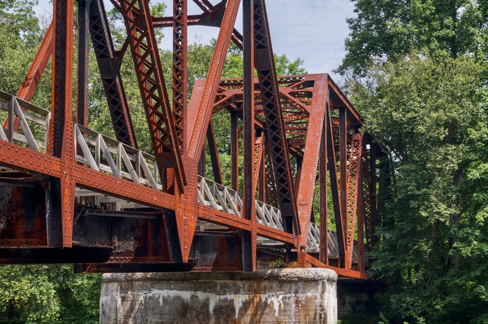 an old rusted metal bridge over a river