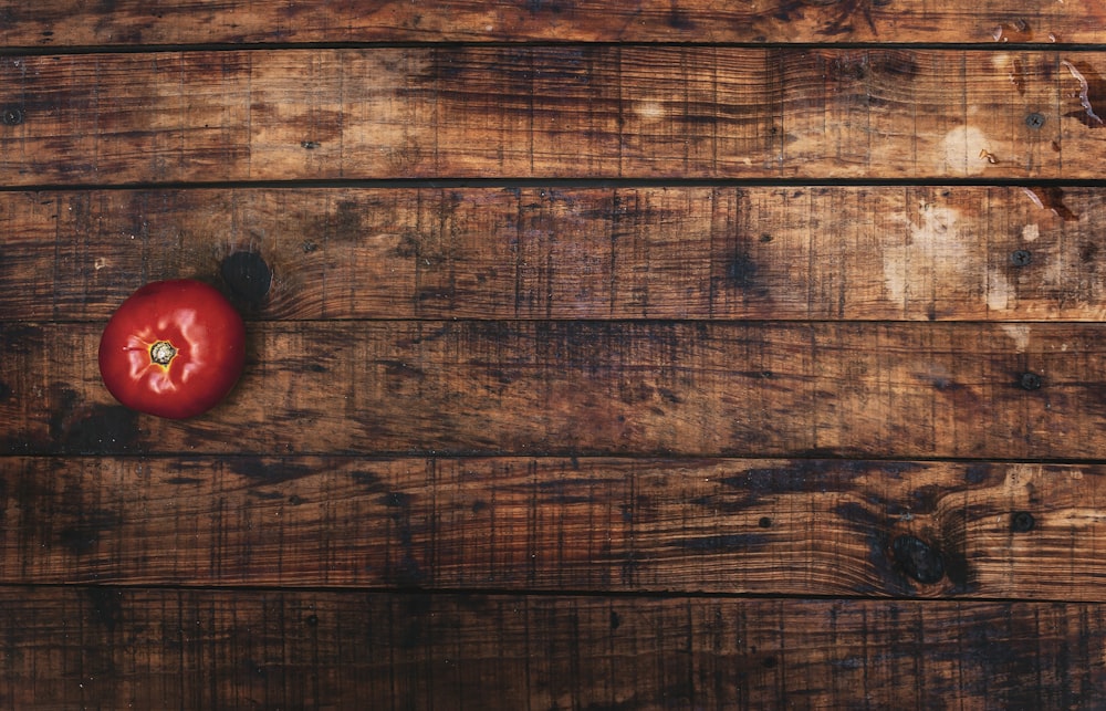 eine rote Paprika, die auf einem Holztisch sitzt