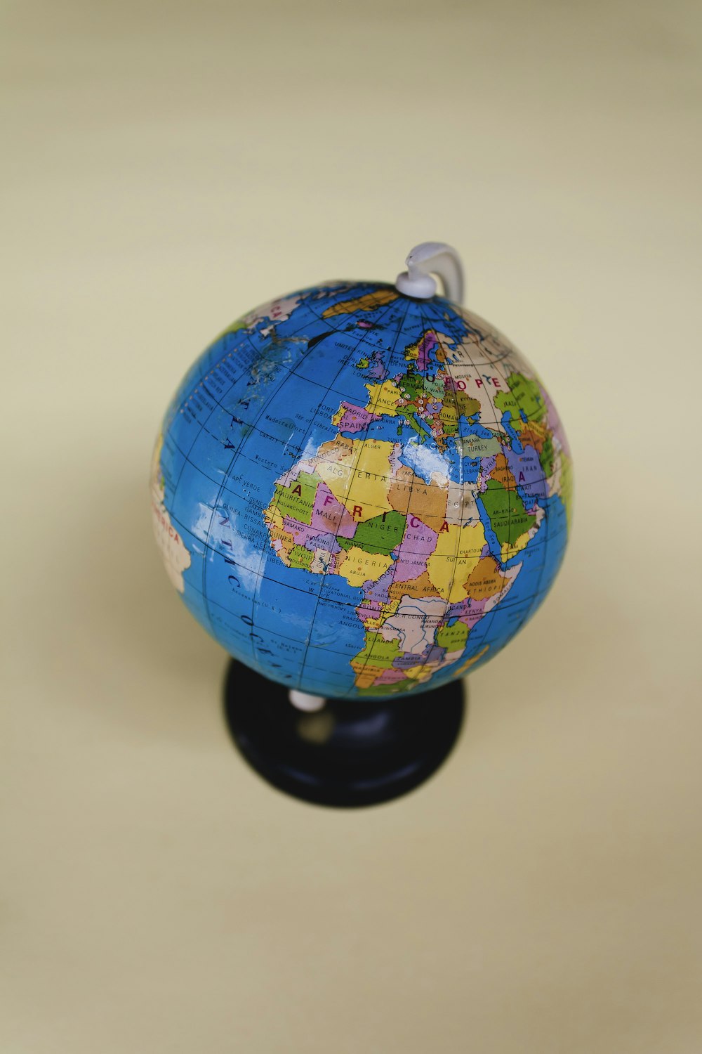 a small blue and yellow globe on a black stand