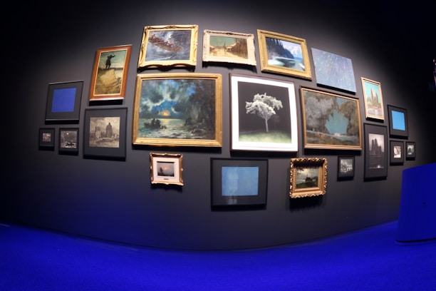 An artistic arrangement of vibrant photographs and artwork on a gallery wall.