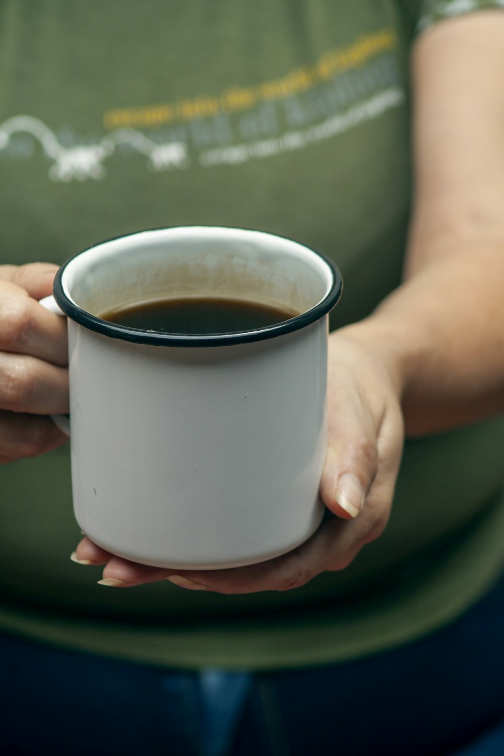 una donna che tiene una tazza di caffè tra le mani
