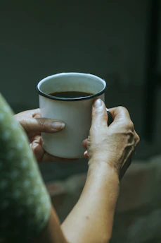 Hands exchanging a custom mug with an emotional message, set against a soft beige background.