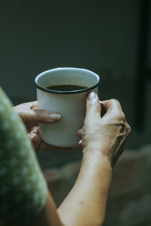 A close-up of hands holding a comforting cup of tea.