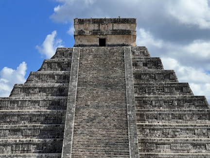 A close-up of a weathered ancient pyramid stone with intricate carvings glowing softly in the sunlight.
