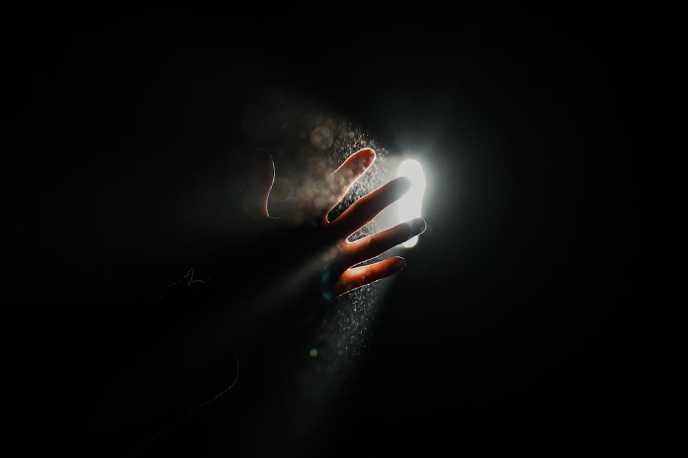 a person holding a lit object in the dark