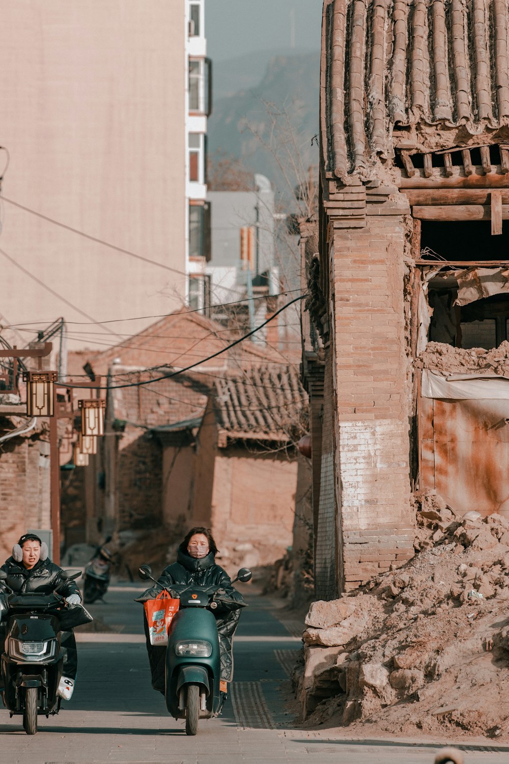 a couple of people riding motorcycles down a street