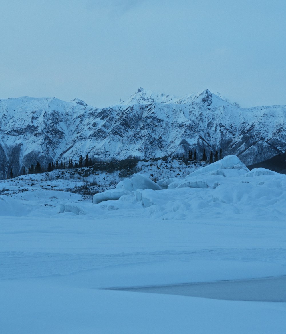 uma paisagem nevada com montanhas ao fundo