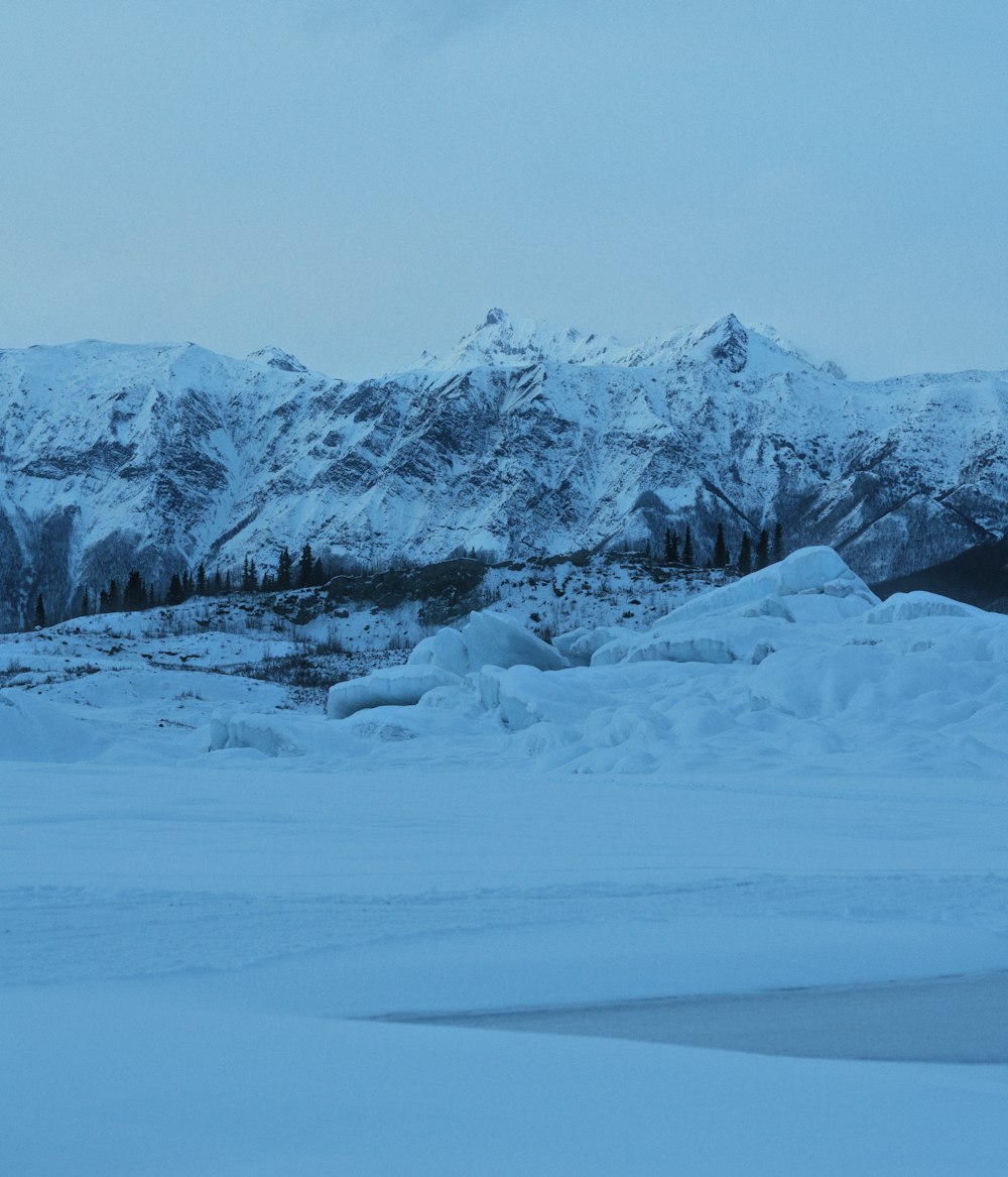 Un paysage enneigé avec des montagnes en arrière-plan