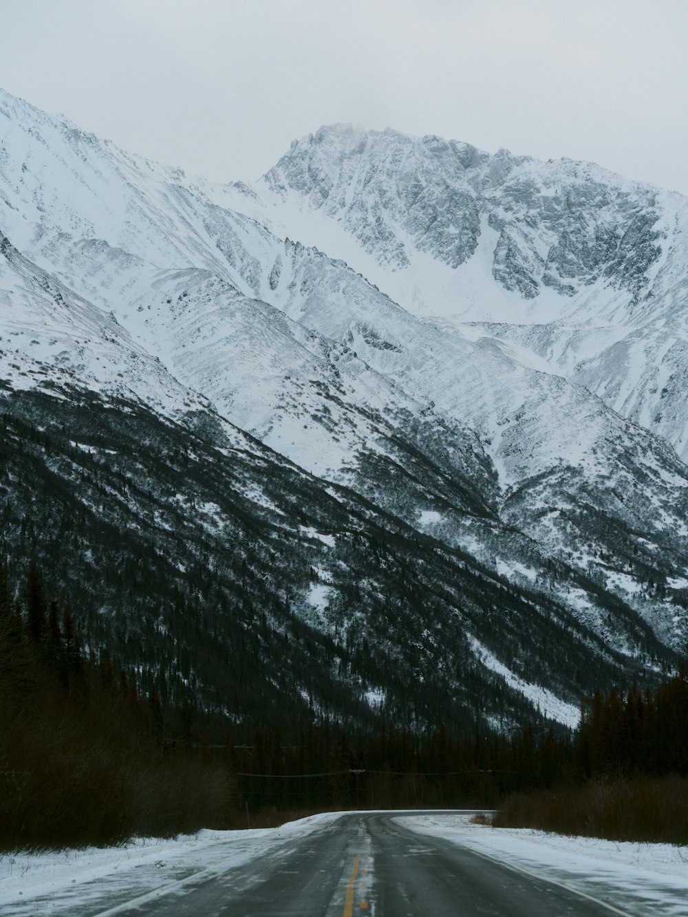 a snow covered mountain with a road in the foreground