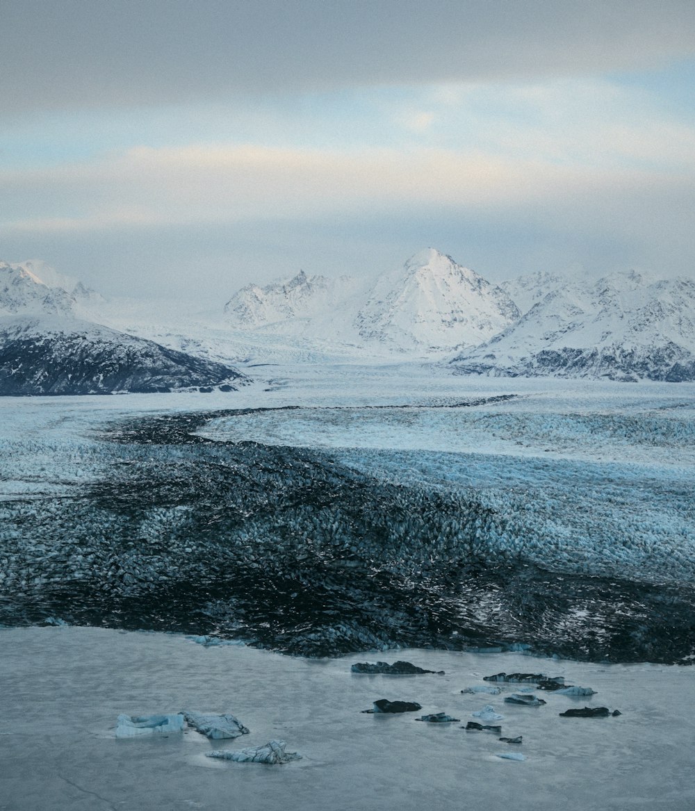 a large body of water surrounded by snow covered mountains