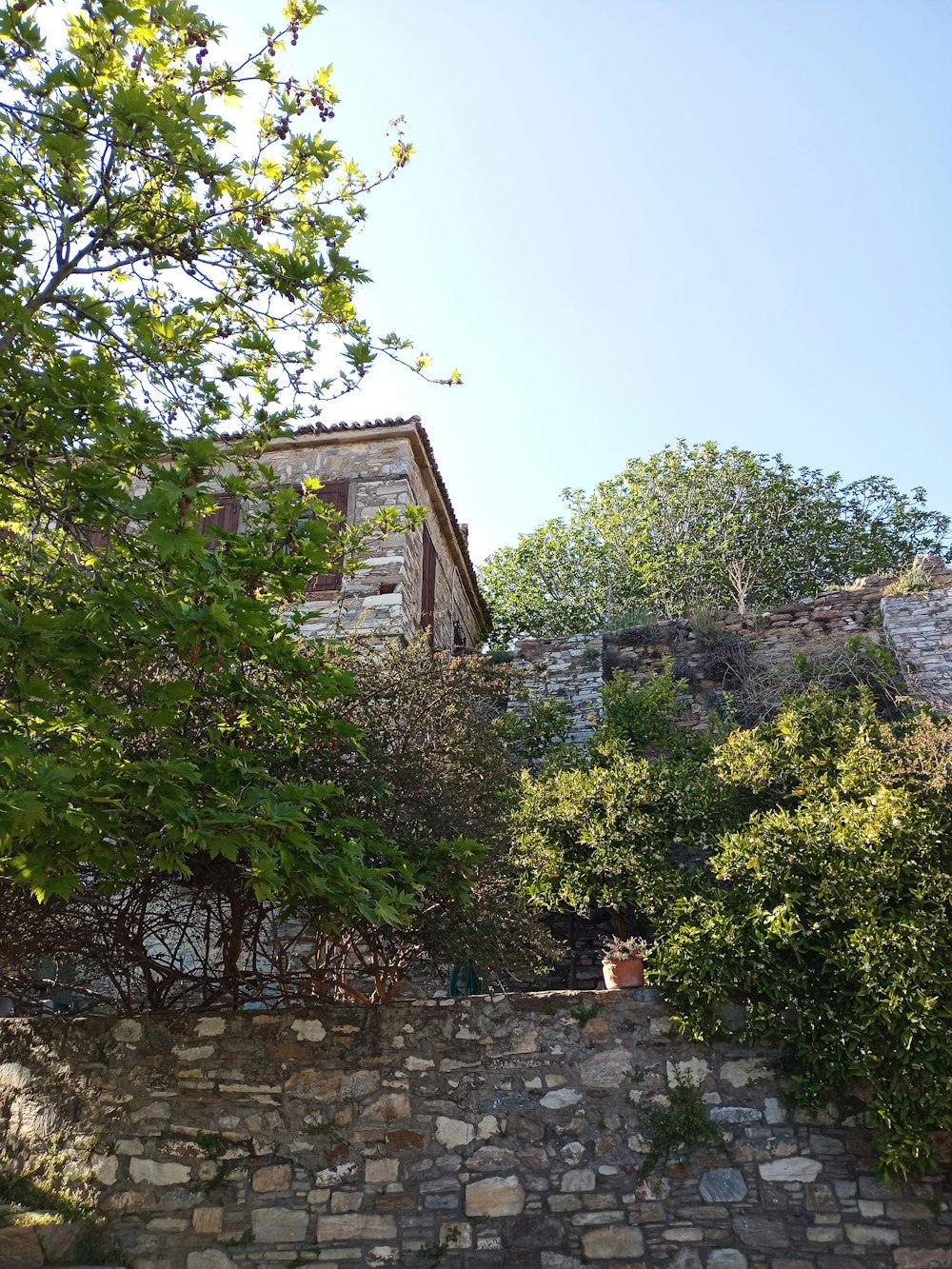 a stone wall with a building in the background