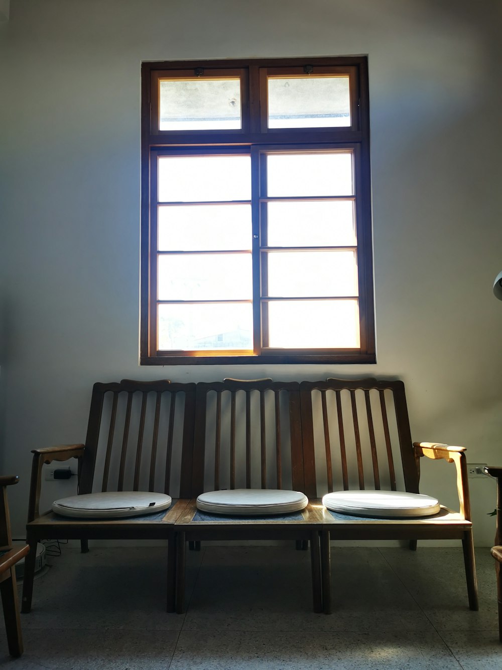 a wooden bench sitting in front of a window