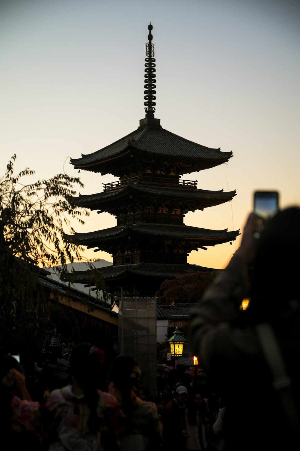 a person taking a picture of a tall pagoda