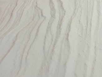 Fine sand with subtle wavy patterns and textures, reminiscent of natural formations.