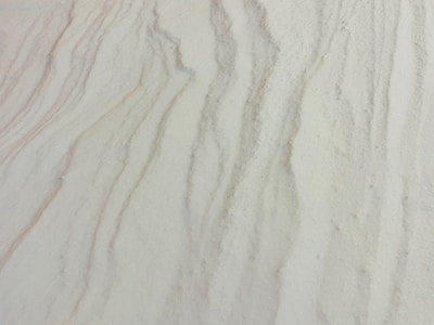 Fine sand with subtle wavy patterns and textures, reminiscent of natural formations.
