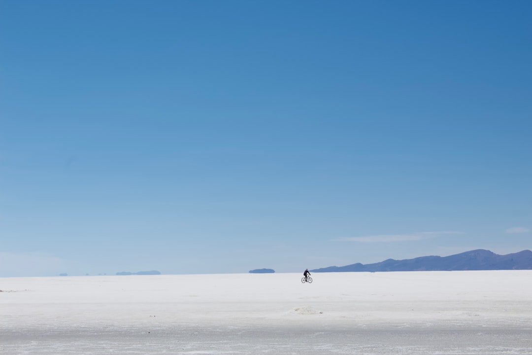a person is flying a kite in the middle of the desert, Biking in the flats
