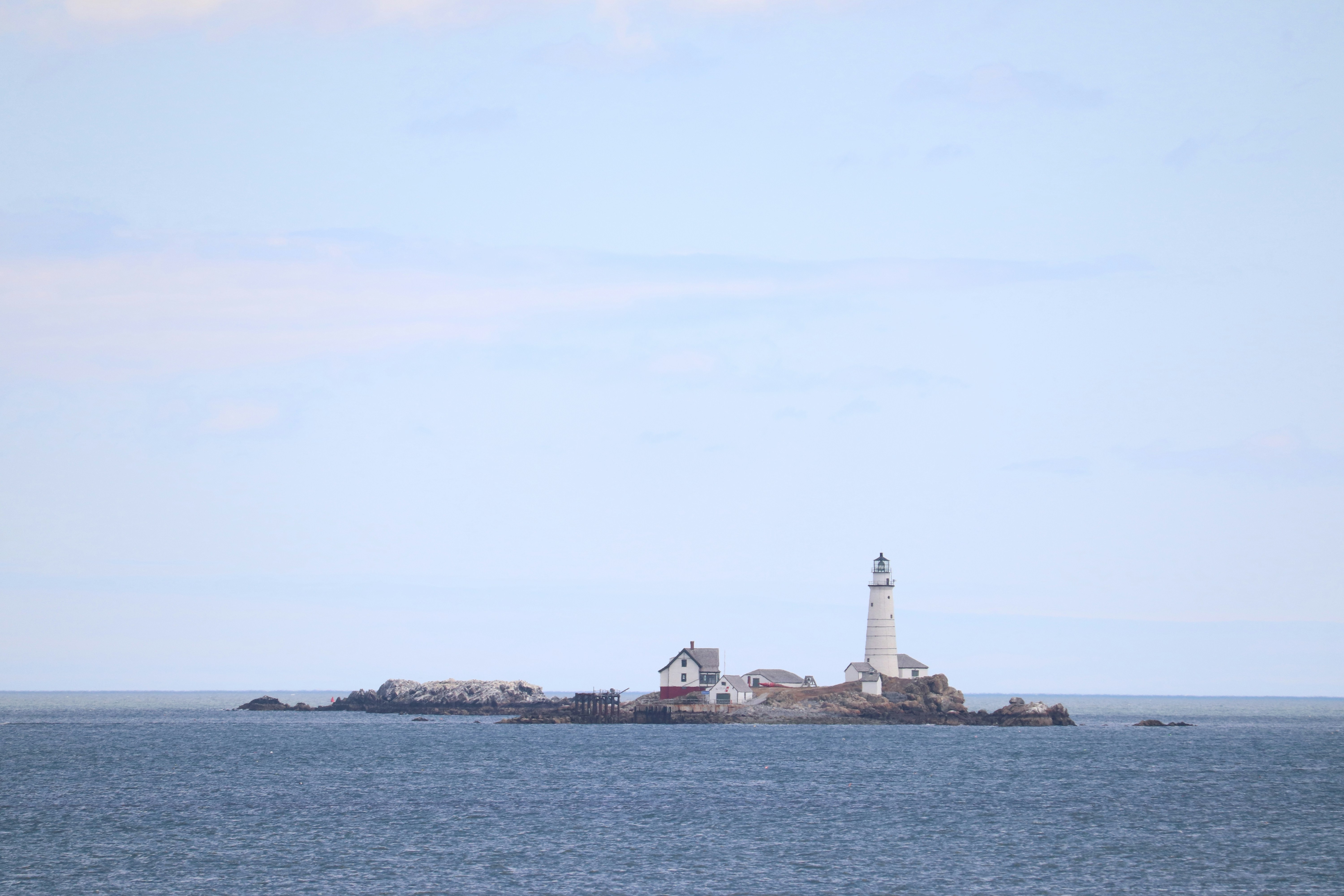 a lighthouse on a small island in the middle of the ocean