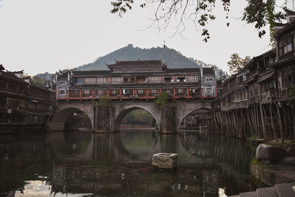 a bridge over a body of water with a building in the background