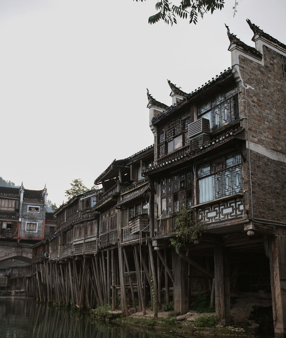 an old wooden building next to a body of water