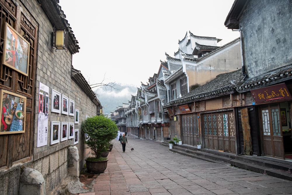 a man walking down a street next to a tall building