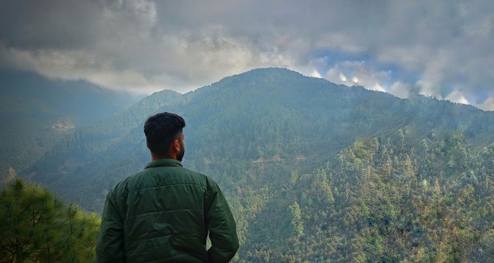 a man standing on top of a lush green hillside