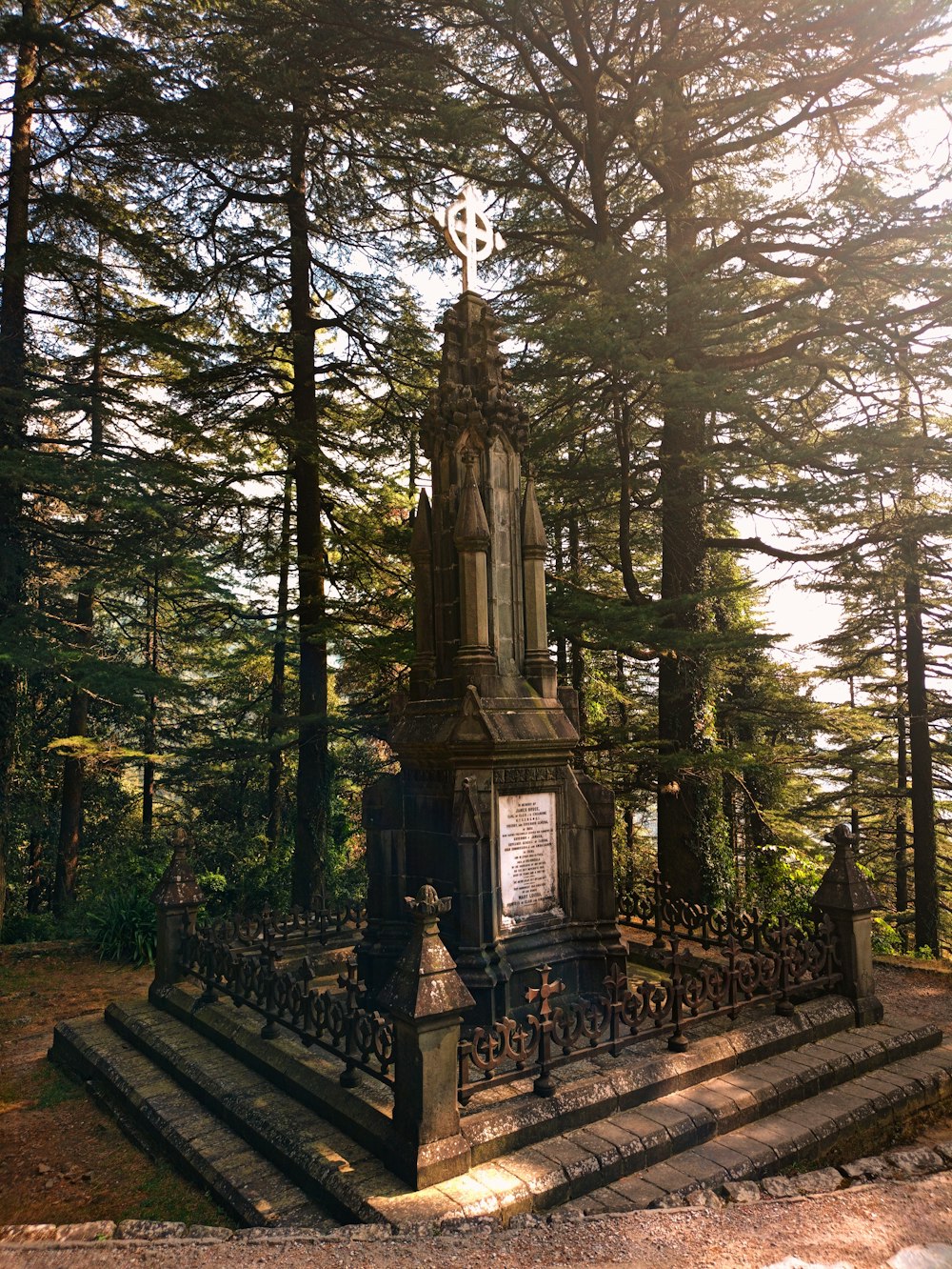 a monument in the middle of a park surrounded by trees