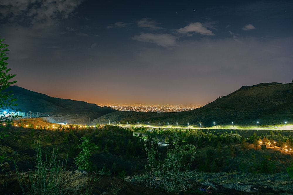 a view of a city at night from a hill