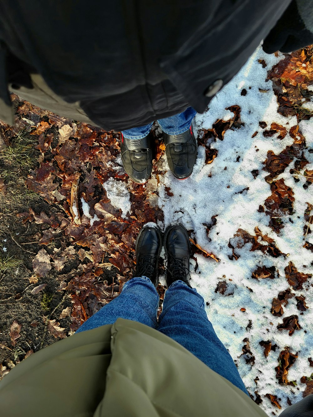a person standing in the snow with their feet up