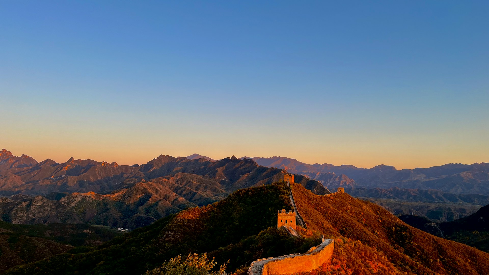 the great wall of china at sunset with mountains in the background