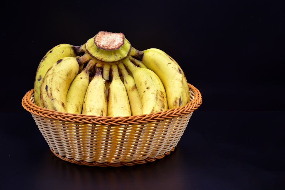 a wicker basket filled with ripe bananas