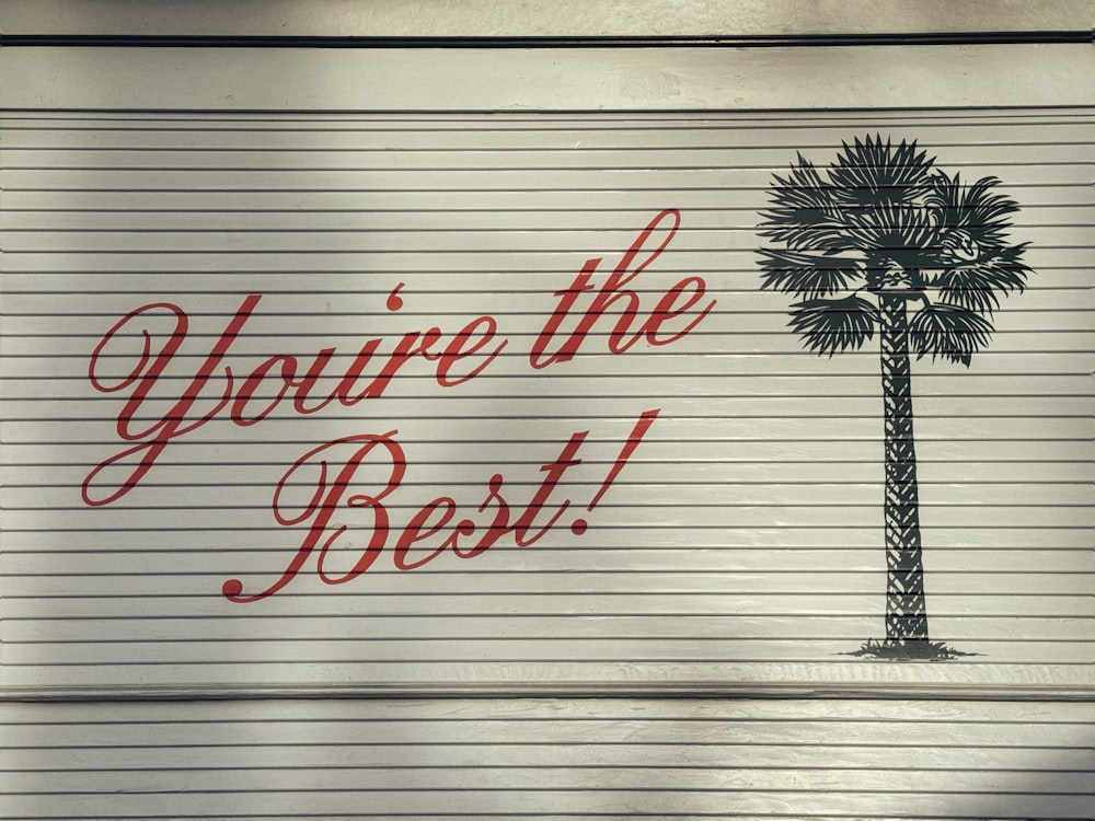 Un cartel que dice que eres el mejor al lado de una palmera