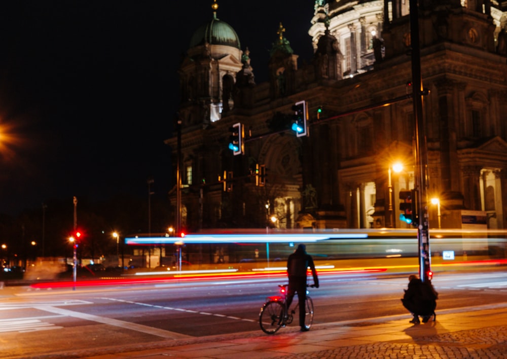 a man riding a bike down a street next to a traffic light